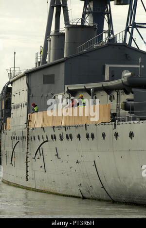 BELFAST, Nordirland: Erste Welt Krieg Schlacht von Jütland veteran Light Cruiser, die 3.700-Tonnen HMS Caroline aus seiner aktuellen Lage in Alexandra Dock Harland und Wolff Heavy Industries in Belfast Dock für eine geplante Rumpf Inspektion und Reparatur, Freitag, 28. Oktober 2016 verschoben. Zwei Schlepper abgeschleppt, das Schiff von seinen verankerungen mit dem Belfast Dock an der Mündung des Hafen. Dies ist Ihre erste Docking für fast drei Jahrzehnte und ein maritimes Ereignis nur durch ihre Rückreise voraussichtlich noch vor Weihnachten zu abgestimmt werden. - HMS Caroline ist jetzt ein stolzes Denkmal für die 10.000 Iren, die verloren Stockfoto