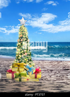 Geschmückten Weihnachtsbaum auf sandigen Strand über das Meer mit suny Sky Stockfoto