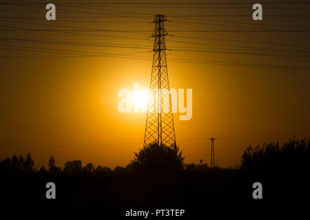 Grüne Energie Konzept, Strom Bahnhof, in der Nähe von Hochspannungsleitungen bei Sonnenuntergang. die Verteilung von Strom entfernt. hohe Spannung Stockfoto