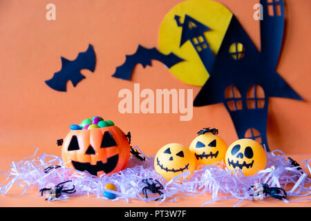 Konzept mit Halloween haunted House schloss und Kürbisse Schaufel und Spinne auf orangem Hintergrund. Stockfoto