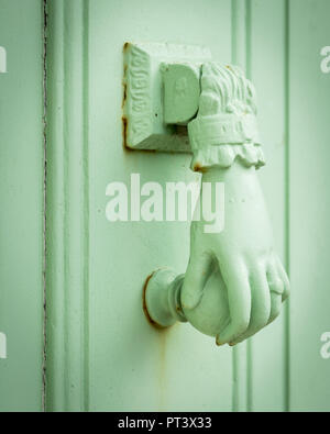 Nahaufnahme von einem Pastell grün gefärbten doorknocker in Form einer Hand Stockfoto