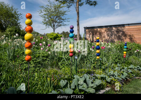 Sticks mit bunten Kugeln im Garten an einem sonnigen Tag im Sommer Stockfoto