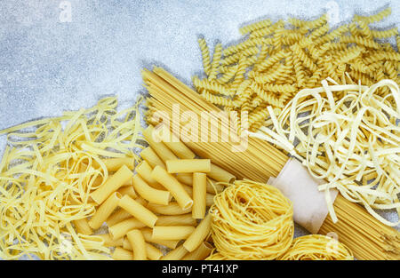 Frische rohe Pasta aus Vollkornmehl. Spaghetti, Eiernudeln, Tortiglioni, Fusilli und Nester. Die Aussicht von oben. Selektiver Fokus Stockfoto