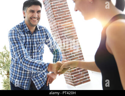 Jungunternehmer und Geschäftsfrau Händeschütteln im modernen Büro Halle. Stockfoto