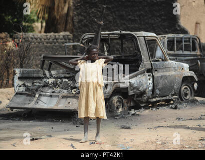 Januar 22, 2013 - Diabaly, Mali: Bewohner von Diabaly watch die Wracks von al-Qaida Fahrzeuge, die von französischen Luftangriffen zerstört. Des Maliens regardent les Schlachtkörper carbonisŽes de Fahrzeuge d'AQMI detruits Gleichheit des frappés eyriennes francaises. *** Frankreich/KEINE VERKÄUFE IN DEN FRANZÖSISCHEN MEDIEN *** Stockfoto