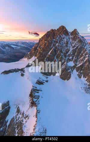 Luftaufnahme der Hubschrauber im Flug in Richtung Piz Roseg bei Sonnenuntergang, Berninagruppe, Grenze zwischen Italien und der Schweiz Stockfoto