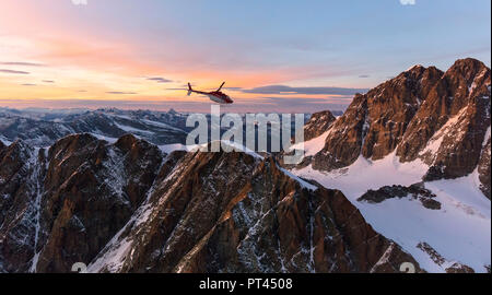 Luftaufnahme der Hubschrauber im Flug in Richtung Piz Roseg bei Sonnenuntergang, Berninagruppe, Grenze zwischen Italien und der Schweiz Stockfoto