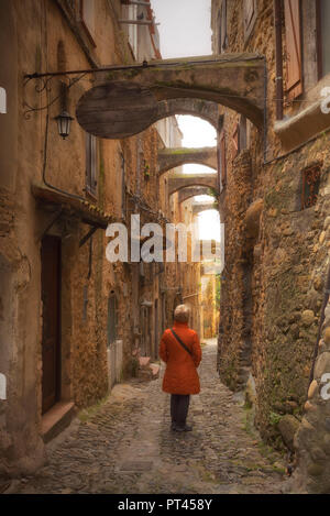 Ein Tourist beobachtet die Architektur einer Straße von Bussana Vecchia, Sanremo, Provinz Imperia, Ligurien, Italien, Europa, Stockfoto