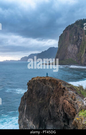 Person, die auf einer Klippe den Sonnenaufgang, Faial, Santana Gemeinde, Region Madeira, Portugal, Stockfoto