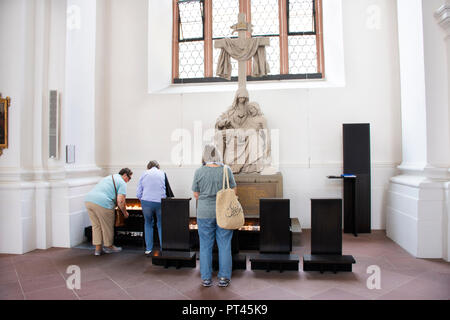 Deutsche Leute verbrennen Kerze für gedenken und beten für die Jungfrau Maria und Jesus Christus Statue in Jesuitenkirche Kirche 25. August 2017 Stockfoto