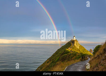 Doppelter Regenbogen über Nugget Point Lighthouse nach dem Sturm, Ahuriri Flach, Clutha-distrikt, Region Otago, Südinsel, Neuseeland, Stockfoto