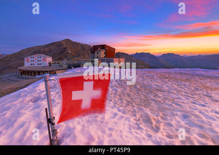 Sonnenaufgang an der Diavolezza Hütte mit der Schweiz Flagge im Vordergrund, Bernina, Engadin, Graubünden, Schweiz, Europa, Stockfoto