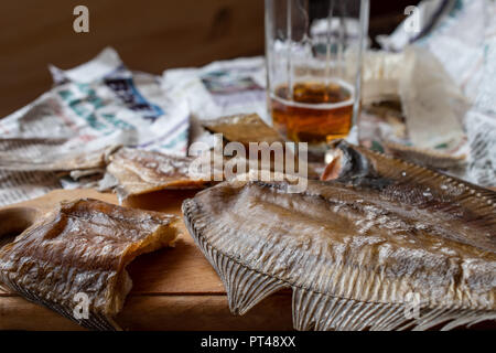 Stillleben mit Bier und eine salzige Ruff die alten Zeitungen Stockfoto