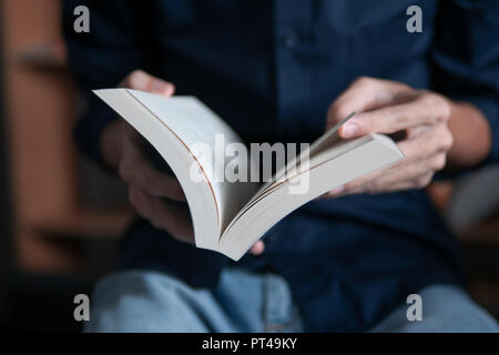 Mann im blauen Hemd ein Buch lesen Stockfoto