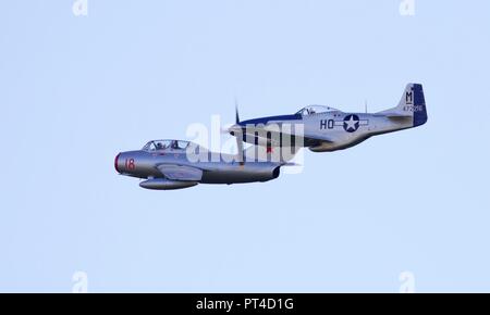 Mikoyan-Gurevich MiG-15 fliegen neben Miss Helen eine North American P-51 Mustang im Jahr 2018 die Schlacht um England Airshow am IWM Duxford Stockfoto