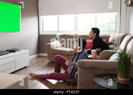 Homosexuelle Paare, Homosexuelle. Gerne männliche Partner und Freunde Sport Spiel im Fernsehen zu Hause und lachte. Green Screen im Fernsehen verfolgen. Stockfoto