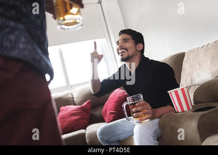 Homosexuelle Paare, Homosexuelle. Gerne männliche Partner und Freunde Sport Spiel im Fernsehen zu Hause und lachte. Stockfoto