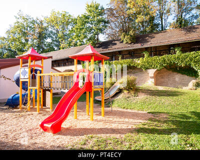 Bild von bunten Spielplatz auf sandigem Untergrund während der Dämmerung Stockfoto