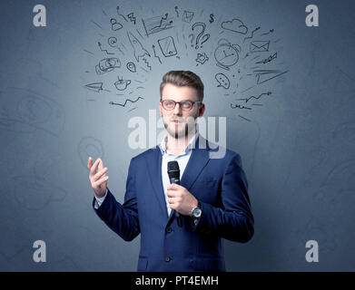 Geschäftsmann sprechen in das Mikrofon mit gemischten Doodles über seinem Kopf Stockfoto