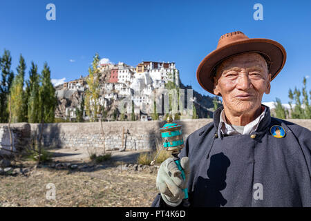 Älterer Mann mit einer Gebetsmühle vor spituk Gompa, Leh, Ladakh, Indien Stockfoto