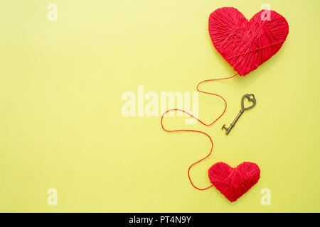 Schlüssel mit zwei Herzen als Symbol der Liebe auf der gelbe Hintergrund. Schlüssel zu meinem Herzen Konzept. Liebe Valentinstag Konzept, Foto legen. Der Schlüssel zu den Herzen für die wahre Liebe. Stockfoto