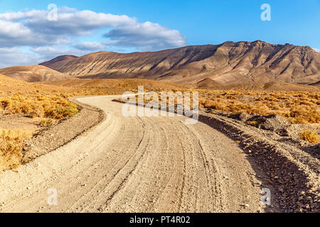 Wicklung des ländlichen schmutzige Straße über vulkanische Landschaft auf Fuerteventura an den Goldenen Stunde Stockfoto