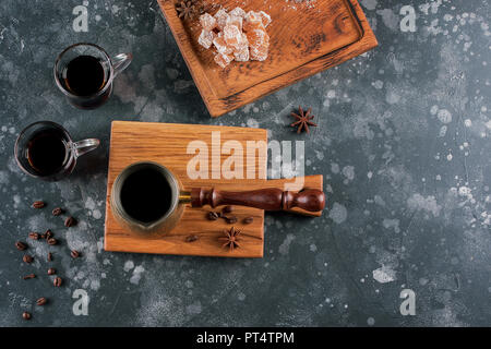 Kaffee Komposition. Ansicht von oben. Hot türkischen Kaffee Topf und orientalische Süßigkeiten auf einem dunklen Hintergrund. Aroma trinken Trinken. Stockfoto