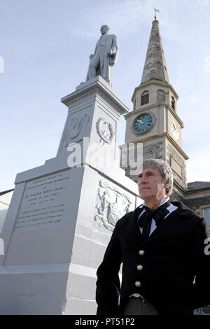 Selkirk, Schottland, Großbritannien. 6. Okt 2018. SELKIRK, Schottland - Oktober 06: Scott's Selkirk lokale Schauspieler John Nichol, in historischen Kostümen, spielt Sir Walter Scott während des Scott Selkirk Tag in Selkirk am Samstag, 06. Oktober 2018, für die Kamera hier posiert von das Denkmal auf dem Marktplatz in Selkirk Marktplatz, mit dem neu renovierten Rathaus/Sitzungssaal Clock Tower. (Foto von Rob Grau/Freiberufler): Rob Grau/Alamy leben Nachrichten Stockfoto