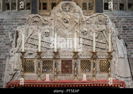 Brügge, Flandern, Belgien - 19 September 2018: Altar mit rot und gold Dekoration hat einen grauen Hintergrund Zement mit Schädel, Knochen, Werkzeuge und ladde Stockfoto