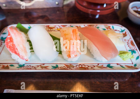 Nahaufnahme von Sushi set Sashimi und Sushi Rollen auf Platte mit Wasabi und traditionellen Tabelle Stockfoto