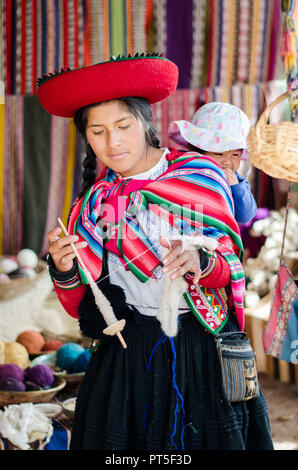 Chinchero, Peru - 15.September 2016: eine junge Frau in traditioneller Kleidung erklärt die Stricken Prozess, das Färben von Alpaka und Schafwolle beinhaltet Stockfoto