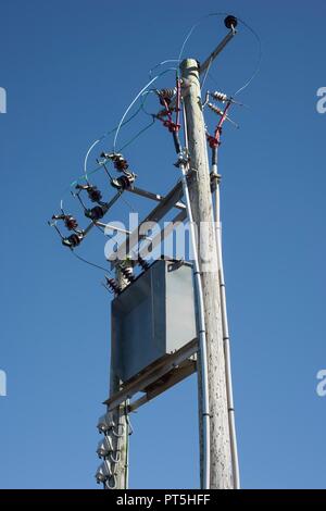 Leitungen von einem lokalen Unterstation ein verteilungstransformator, wandelt elektrische Energie in eine viel niedrigere Spannung für den lokalen Verbrauch verbunden. Stockfoto