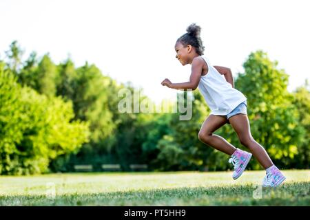 Kleines Mädchen im Park, ein Lächeln auf den Lippen. Stockfoto