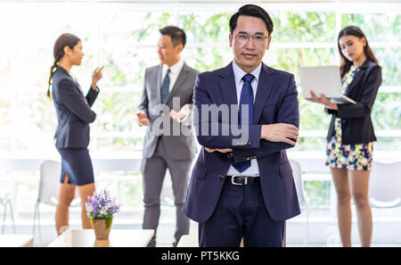 Portrait von Geschäftsmann witn Business Team im Hintergrund im Fenster Stockfoto