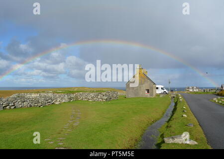 Voller Regenbogen über dem Meer mit Feldern im Vordergrund in der Nähe der Arnol Blackhouse Museum Insel Lewis Äußere Hebriden Western Schottland Großbritannien Stockfoto