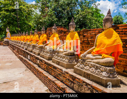 Thailand, Reihe von Buddha Statuen mit orangefarbenen Roben in Ayutthaya alte Tempel Stockfoto