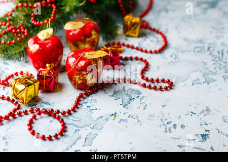 Weihnachten Dekorationen in Form von Äpfeln, tanne Zweig und Red Garland - Perlen auf einen hellen Hintergrund Stockfoto