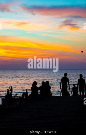 Die Leute auf der Bach bei Sonnenuntergang am Karon Beach Phuket Thailand Stockfoto