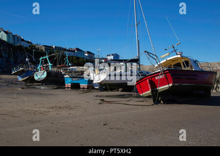 Fischerboote auf dem Sand mit der Ebbe in New Quay Hafen, Ceredigion, Wales. Foto 29. September 2018 getroffen Stockfoto