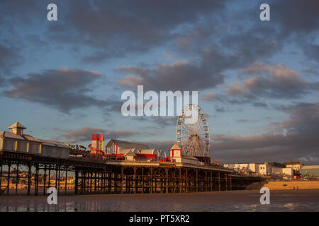 Golden Sunset am Pier in Blackpool mit dem Turm, Rad & Promenade. Es gibt auch einen murmuration oben in der schönen blauen Himmel. Stockfoto