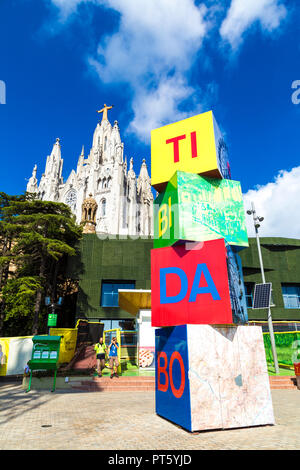 Zeichen der Vergnügungspark Tibidabo mit dem Tempel des Heiligen Herzen Jesu Kirche im Hintergrund, Barcelona, Spanien Stockfoto