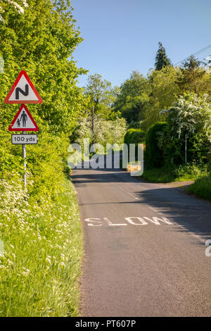 Warndreieck Verkehrsschilder für Fußgänger mit langsamen Kurven und Zeichen auf einem Britischen country lane, Sharpenhoe, Großbritannien Stockfoto