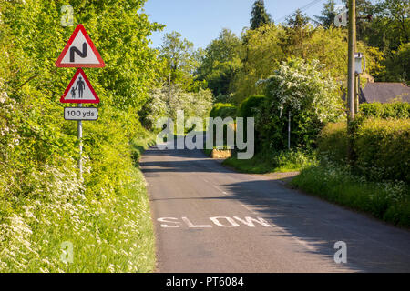 Warndreieck Verkehrsschilder für Fußgänger mit langsamen Kurven und Zeichen auf einem Britischen country lane, Sharpenhoe, Großbritannien Stockfoto