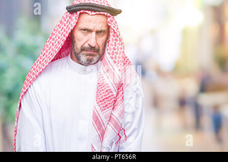 Senior arabischen Mann mit kufiya über isolierte Hintergrund Skeptiker und nervös und runzelte verärgert wegen des Problems. Negative Person. Stockfoto