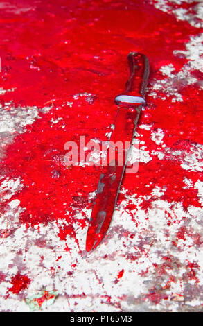 Konzeptionelle Bild von einem scharfen Messer mit Blut auf ihm ruht auf einem Betonboden. Konzept Foto von Mord und Verbrechen Stockfoto