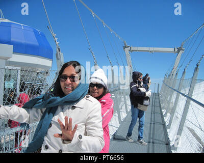 Indische Touristen auf der Klippe zu Fuß auf dem Titlis, Schweiz Stockfoto