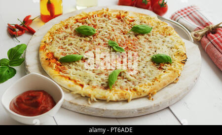 Köstliche italienische Pizza serviert auf Holztisch, Schuß von der Seite Stockfoto