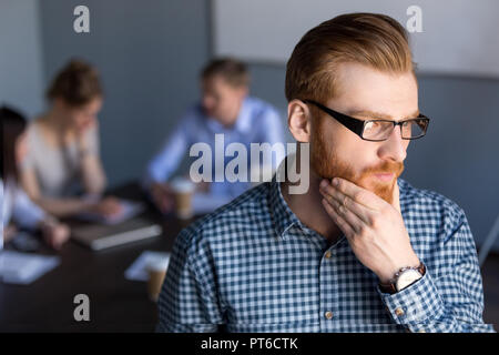 Nachdenklich Geschäftsmann weg schauen die Hand am Kinn plannin Stockfoto