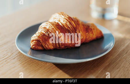 In der Nähe von frisch gebackenen Croissant auf blauem Teller. Stockfoto