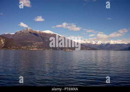 Italien, Bellagio, Comer See, malerischen Blick auf schneebedeckte Berge gegen den blauen Himmel mit Schwänen auf dem See Stockfoto